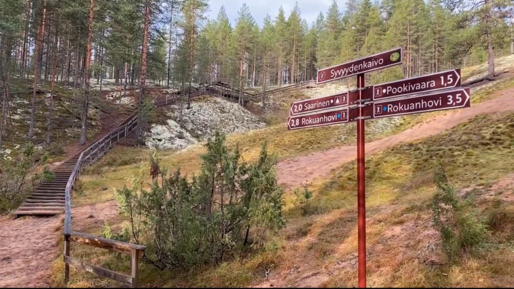 Kuva kävelyreitistä metsässä. Kuvassa reittiohjeet eri poluille.