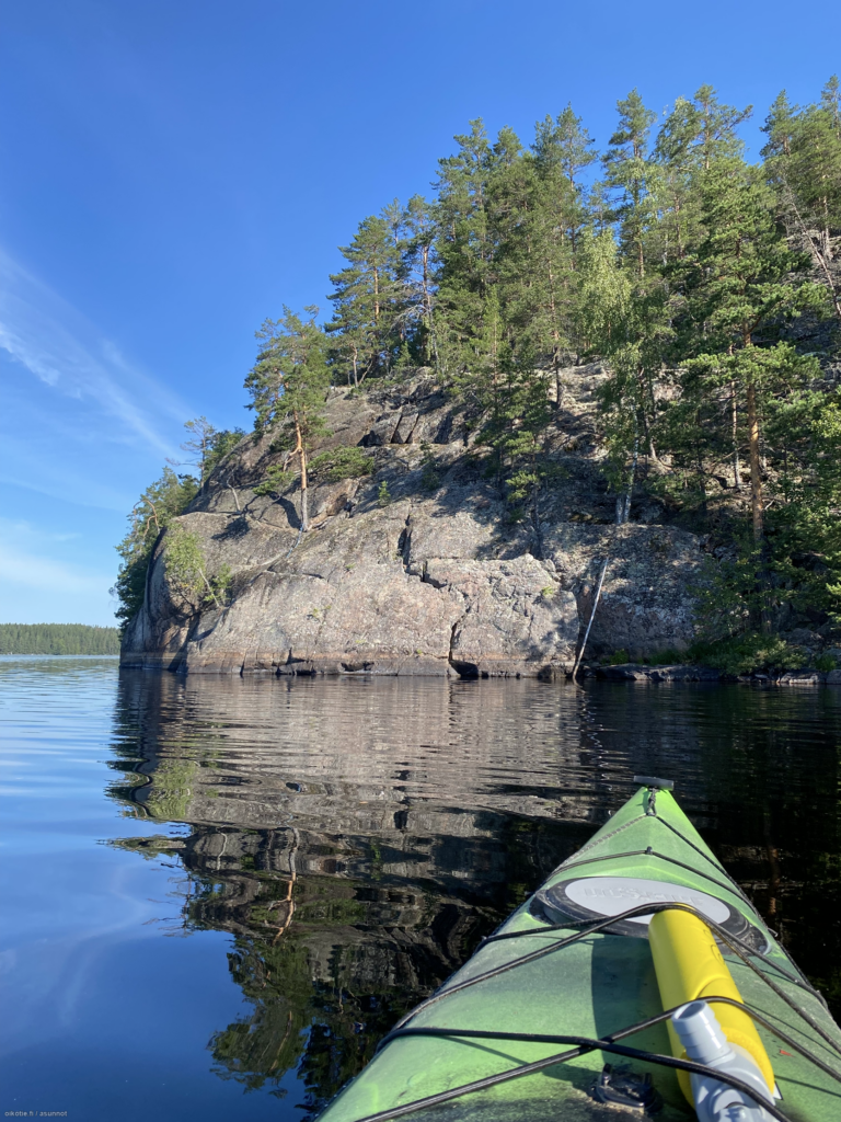 Kanootti järvellä kellumassa kohti kallioista saarta.